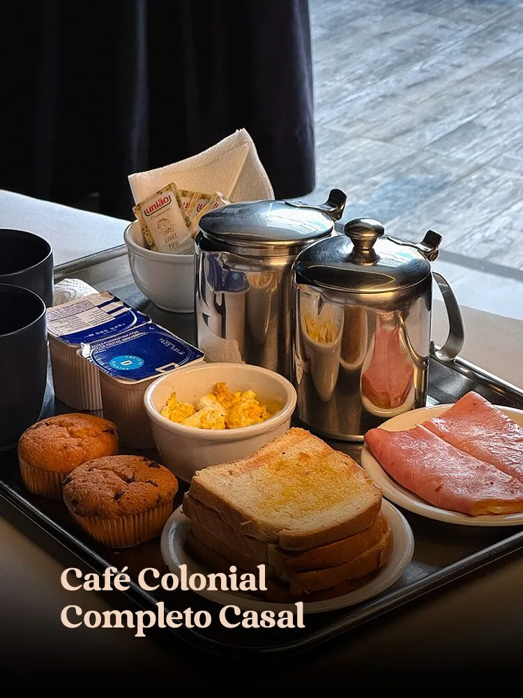 Bandeja inox de café da manhã para casal: bules de inox, torradas, muffins, presunto, ovos mexidos, com sachês · cardápio do Motel Opium