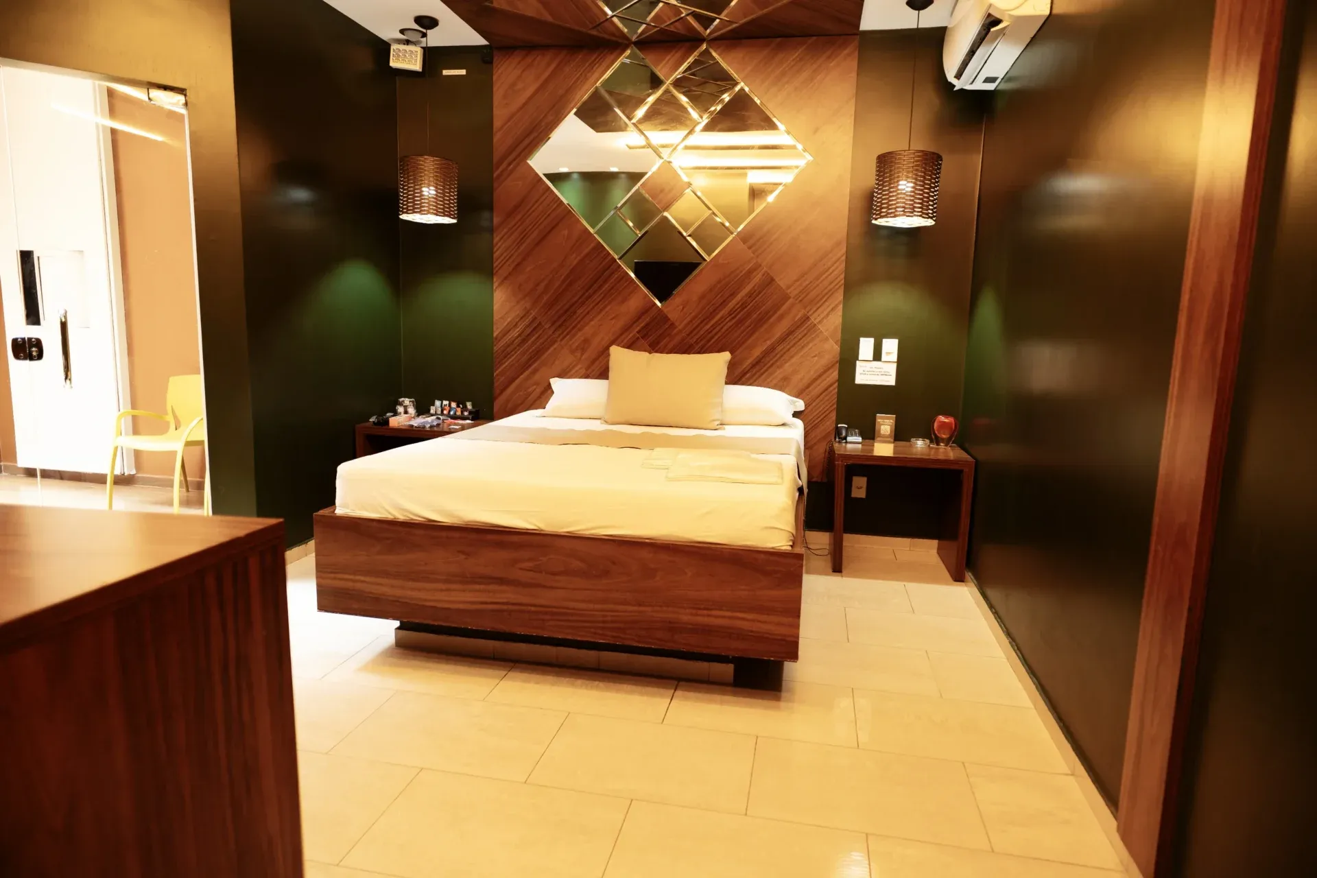 Suíte VIP do Motel Opium em Boa Vista: Suíte em madeira e verde-musgo: cama flutuante com base em madeira nobre, painel de cabeceira em lâminas de ma