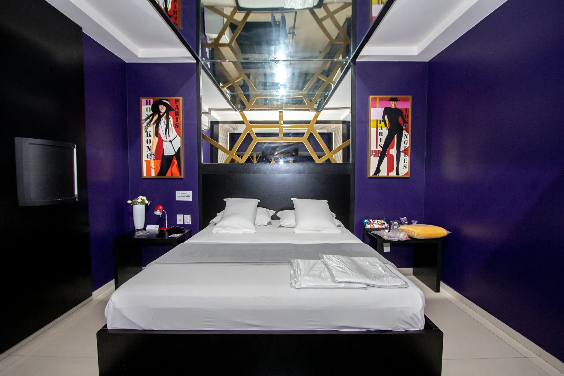 Suíte VIP Plus do Motel Opium em Boa Vista: Exatamente a mesma tomada frontal do quarto roxo de VIP-PLUS-4-1 (mesma cama, pôsteres, teto espelhado, snacks