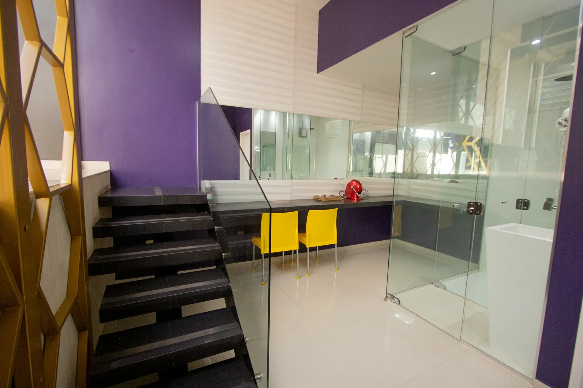 Suíte VIP Plus do Motel Opium em Boa Vista: Área de mezanino/duplex da VIP Plus: escada flutuante preta com guarda-corpo de vidro, bancada de apoio com du