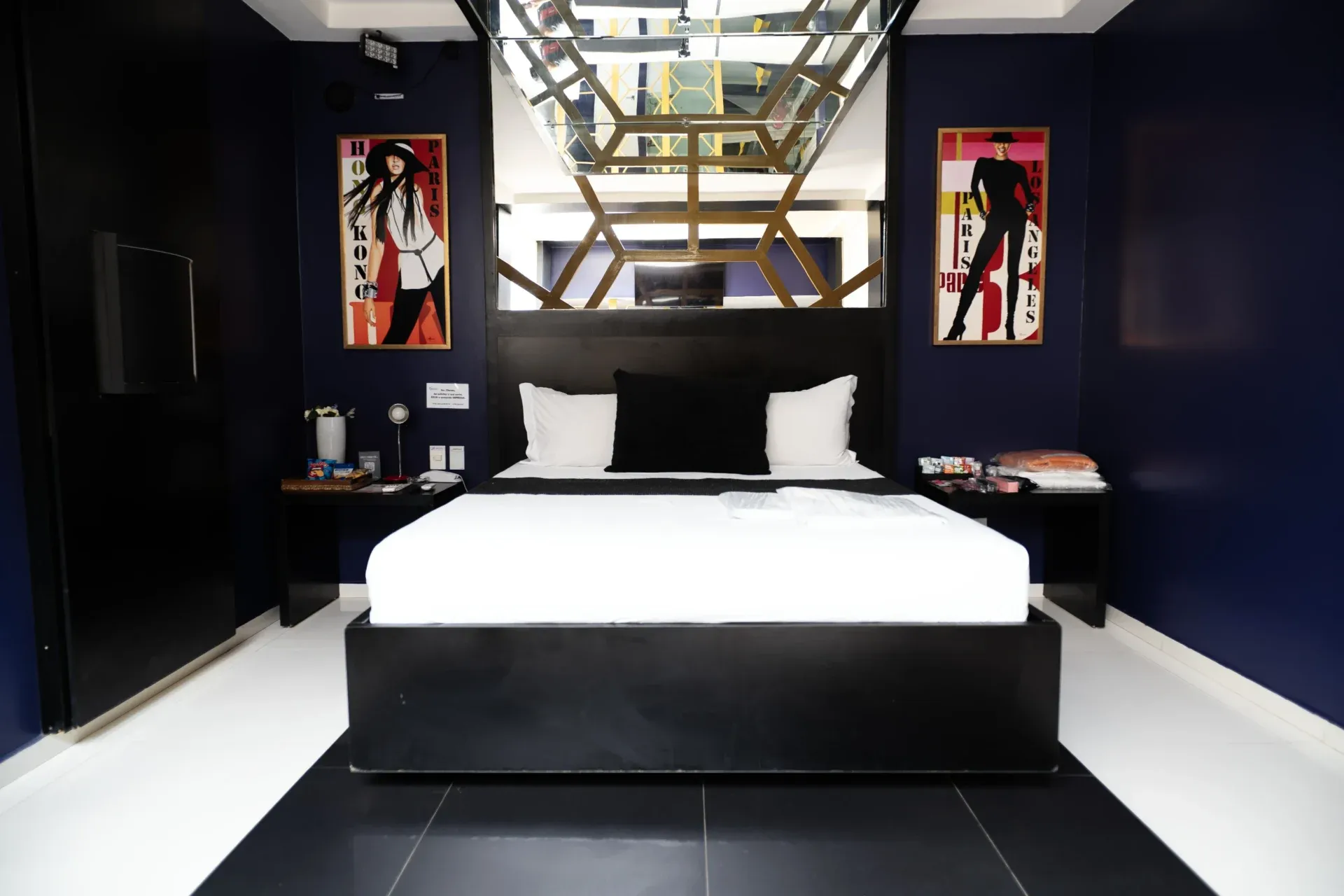 Suíte VIP Plus do Motel Opium em Boa Vista: Suíte fashion em azul-marinho e preto: cama em base preta com roupa branca e almofada preta, dossel de teto es